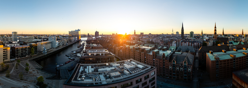 Aerial view of the Speicherstadt warehouse district and Elbphilharmonie concert hall at sunset with the city skyline and church spires in Hamburg Hamburg Germany. Aerial view of the Speicherstadt warehouse district and Elbphilharmonie concert hall at sunset with the city skyline and church spires in Hamburg Hamburg Germany.