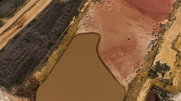 Aerial view of industrial salt mining patterns with brown and yellow sediment filled pools textured sand and earthworks in the landscape in Kalbarri Western Australia Australia. Aerial view of industrial salt mining patterns with brown and yellow sediment filled pools textured sand and earthworks in the landscape in Kalbarri Western Australia Australia.