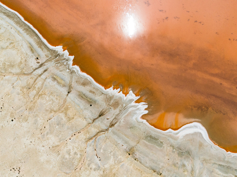 Aerial view of the salt lake in the Mallee region showing vibrant orange water contrasting with white salt crusts and dry arid terrain in Woorinen North Victoria Australia. Aerial view of the salt lake in the Mallee region showing vibrant orange water contrasting with white salt crusts and dry arid terrain in Woorinen North Victoria Australia.