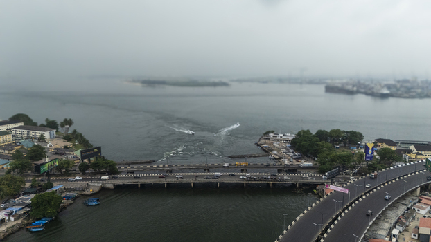 Aerial view of Lagos Island bridge spanning the water with traffic boats moving in the lagoon and urban surroundings in Lagos Lagos Nigeria. Aerial view of Lagos Island bridge spanning the water with traffic boats moving in the lagoon and urban surroundings in Lagos Lagos Nigeria.