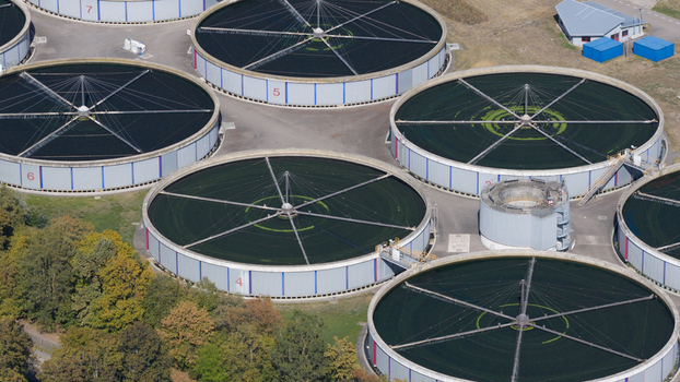 Aerial view of Klarwerk Karlsruhe wastewater treatment plant featuring large circular sedimentation tanks and industrial infrastructure in Karlsruhe Baden Wurttemberg Germany.