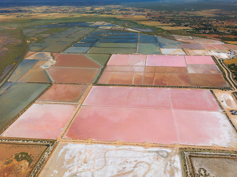 Aerial view of the colorful pink and white salt evaporation ponds at Salines des Trenc under a clear sky in Campos Islas Baleares Spain. Aerial view of the colorful pink and white salt evaporation ponds at Salines des Trenc under a clear sky in Campos Islas Baleares Spain.