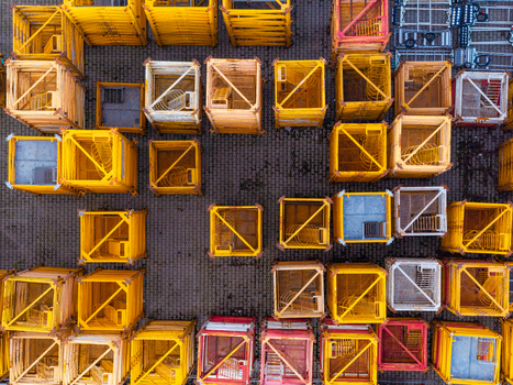 Aerial view of tower crane mast sections arranged in a grid pattern on a paved surface in Masovian Voivodeship Poland.