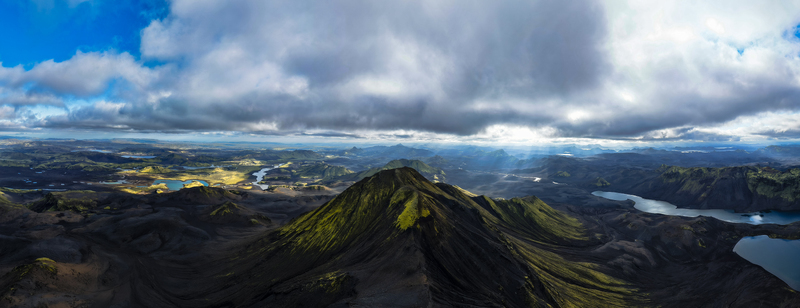 Aerial view of sun rays filter through the clouds illuminating the rugged peaks and still lakes creating a stunning contrast of light and shadow Iceland. Aerial view of sun rays filter through the clouds illuminating the rugged peaks and still lakes creating a stunning contrast of light and shadow Iceland.