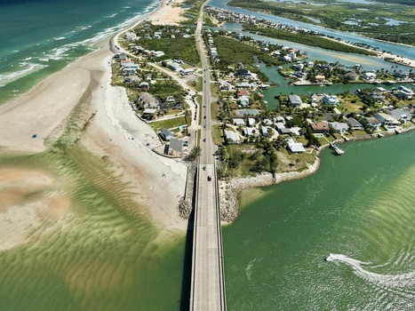 Aerial view of Matanzas Inlet showing the bridge connecting coastal residential areas with sandy beaches and turquoise waters in St. Johns County Florida United States. Aerial view of Matanzas Inlet showing the bridge connecting coastal residential areas with sandy beaches and turquoise waters in St. Johns County Florida United States.