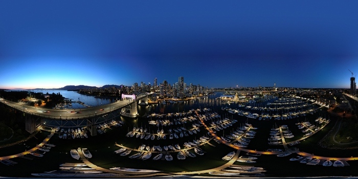 Aerial view of the Vancouver Downtown 360 degree Panorama featuring Burrard Street Bridge marina boats and illuminated city skyline in Vancouver British Columbia Canada.
