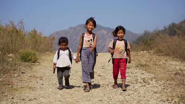 View of schoolgirls walking on a rural road Nepal.
