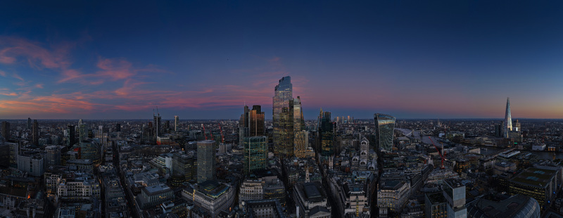 Aerial view of the City of London financial district skyscrapers and The Shard illuminated at twilight under a colorful sunset sky London England United Kingdom.