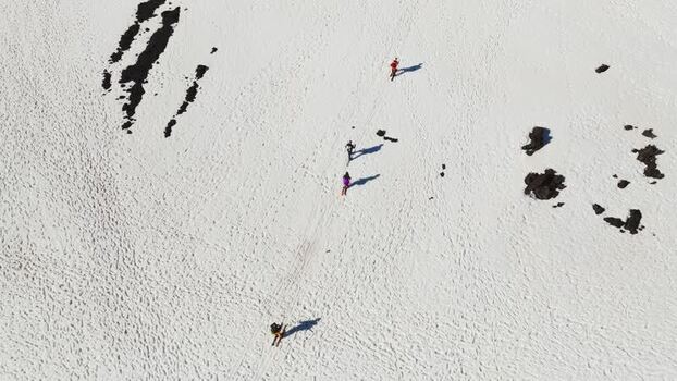 Aerial view of people skiing on the snowy slopes of Mount Etna Italy. Aerial view of people skiing on the snowy slopes of Mount Etna Italy.