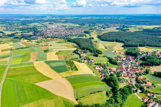 Aerial view of the historic town of Neunkirchen am Brand surrounded by vibrant agricultural fields and lush green forests under a bright sky with fluffy clouds in Neunkirchen am Brand Bavaria Germany. Aerial view of the historic town of Neunkirchen am Brand surrounded by vibrant agricultural fields and lush green forests under a bright sky with fluffy clouds in Neunkirchen am Brand Bavaria Germany.