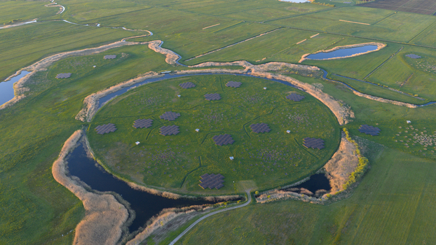Aerial view of the LOFAR superterp radio telescope station featuring circular antenna arrays on a green island surrounded by water channels and lush fields Buinen Drenthe Netherlands. Aerial view of the LOFAR superterp radio telescope station featuring circular antenna arrays on a green island surrounded by water channels and lush fields Buinen Drenthe Netherlands.