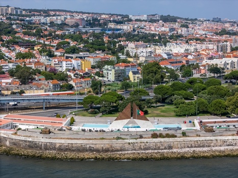 Lisboa Portugal 25 July 2026 Aerial view of the Monument to the Overseas Combatants along the waterfront surrounded by green parks urban buildings and the Lisbon cityscape.
