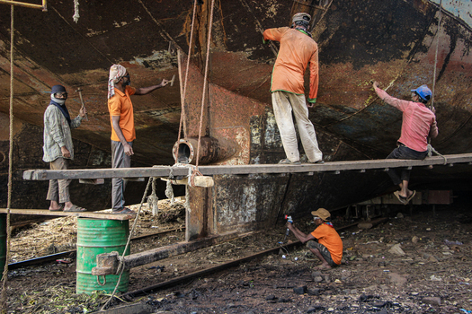 Keraniganj Bangladesh 03 November 2023 View of workers repairing and painting the rusty hull of a large vessel at Shipyard Dhaka.