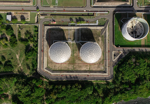 Aerial view of industrial storage tanks surrounded by roads and lush greenery in Bajos de Haina San Cristobal Province Dominican Republic.