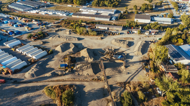 Aerial view of an industrial gravel and sand processing facility with large piles of aggregate conveyor belts and storage structures in Sremska Mitrovica Vojvodina Serbia.