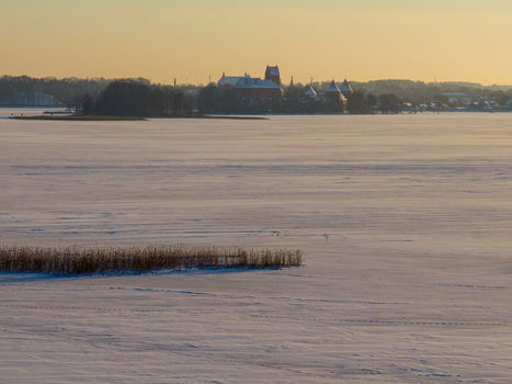 Aerial view of Trakai Island Castle across the frozen Lake Galve covered in snow during a golden sunset Trakai Vilniaus apskritis Lithuania.