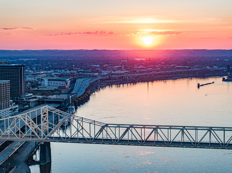 Aerial view of the George Rogers Clark Memorial Bridge spanning the Ohio River at sunset with the city skyline under a vibrant pink sky in Louisville Kentucky United States. Aerial view of the George Rogers Clark Memorial Bridge spanning the Ohio River at sunset with the city skyline under a vibrant pink sky in Louisville Kentucky United States.