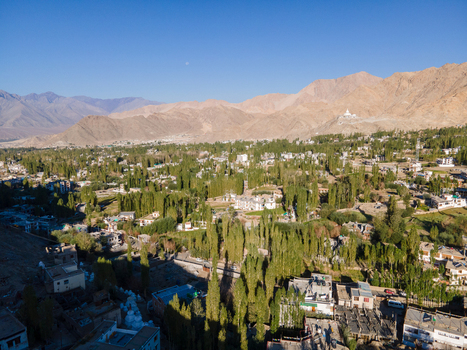 Aerial view of the town of Leh nestled among lush green trees and surrounded by the arid mountain ranges of the Himalayas in Leh Ladakh India. Aerial view of the town of Leh nestled among lush green trees and surrounded by the arid mountain ranges of the Himalayas in Leh Ladakh India.