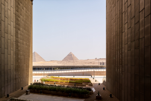 Giza Egypt 16 May 2026 View of the Grand Egyptian Museum modern architecture framing the Great Pyramids of Giza under a clear sky.
