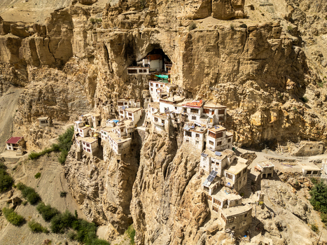 Aerial view of Phukthal Gompa a historic Buddhist monastery built into a cliffside cave featuring white buildings and traditional architecture in Phukthal Ladakh India.