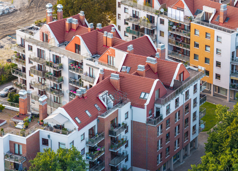 Aerial view of modern apartment buildings with red tiled roofs balconies and brick facades in a residential area in Gdansk Pomeranian Voivodeship Poland. Aerial view of modern apartment buildings with red tiled roofs balconies and brick facades in a residential area in Gdansk Pomeranian Voivodeship Poland.
