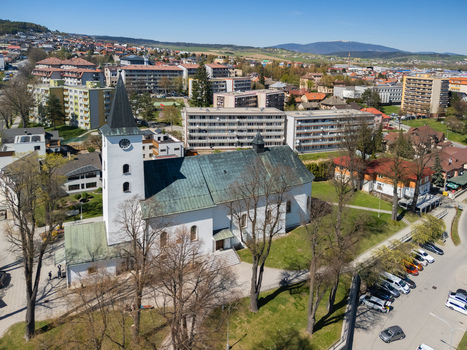 Aerial view of the Roman Catholic Church of Saints Simon and Jude with its white facade and tall steeple surrounded by residential buildings in Namestovo Zilina Region Slovakia. Aerial view of the Roman Catholic Church of Saints Simon and Jude with its white facade and tall steeple surrounded by residential buildings in Namestovo Zilina Region Slovakia.