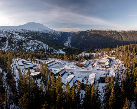 Aerial view of Gaustablikk Fjellresort nestled in snowy mountains with pine forests and winter sunlight in Rjukan Telemark Norway. Aerial view of Gaustablikk Fjellresort nestled in snowy mountains with pine forests and winter sunlight in Rjukan Telemark Norway.