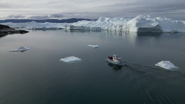 Aerial view of boat navigating Ilulissat Icefjord Greenland. Aerial view of boat navigating Ilulissat Icefjord Greenland.