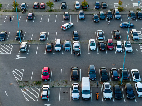 Aerial view of a busy parking lot with various parked cars and people walking between vehicles in Vilnius Vilnius County Lithuania. Aerial view of a busy parking lot with various parked cars and people walking between vehicles in Vilnius Vilnius County Lithuania.