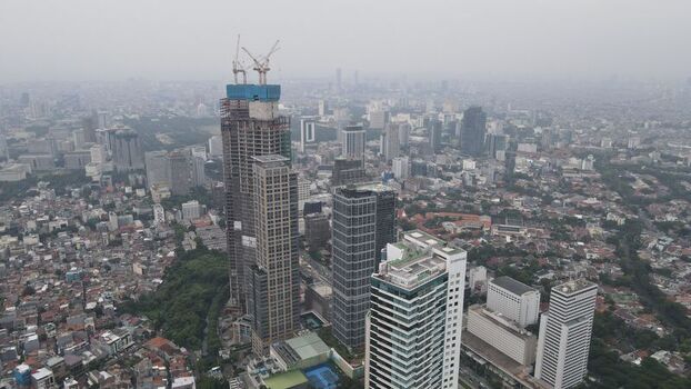 Aerial view of Jakarta Pusat skyscrapers and dense urban landscape with construction cranes in Kecamatan Menteng Daerah Khusus Ibukota Indonesia. Aerial view of Jakarta Pusat skyscrapers and dense urban landscape with construction cranes in Kecamatan Menteng Daerah Khusus Ibukota Indonesia.
