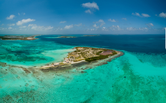 Aerial view of Los Roques archipelago featuring turquoise waters coral reefs and small sandy islands under a clear blue sky in Los Roques Dependencias Federales Venezuela. Aerial view of Los Roques archipelago featuring turquoise waters coral reefs and small sandy islands under a clear blue sky in Los Roques Dependencias Federales Venezuela.