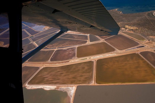 Aerial view of salt evaporation ponds with geometric patterns and coastal waters in Australia. Aerial view of salt evaporation ponds with geometric patterns and coastal waters in Australia.