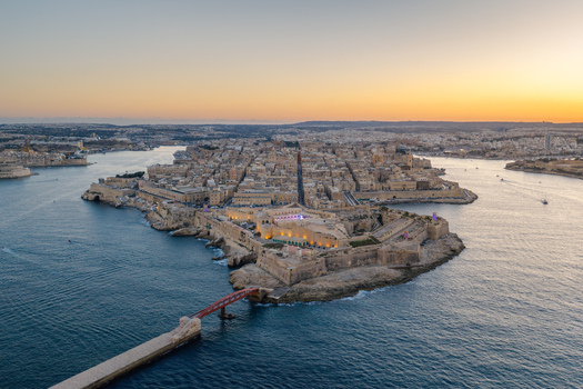 Aerial view of Fort Saint Elmo and the historic city of Valletta at sunset featuring stone fortifications narrow streets and the surrounding Mediterranean Sea in Valletta Port Region Malta. Aerial view of Fort Saint Elmo and the historic city of Valletta at sunset featuring stone fortifications narrow streets and the surrounding Mediterranean Sea in Valletta Port Region Malta.