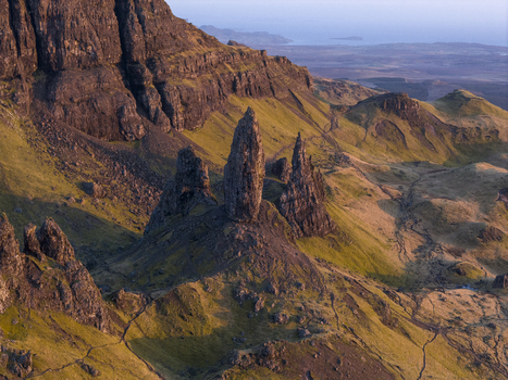 Aerial view of the Old Man of Storr rock formation with jagged pinnacles and grassy slopes during golden hour Isle of Skye Scotland United Kingdom. Aerial view of the Old Man of Storr rock formation with jagged pinnacles and grassy slopes during golden hour Isle of Skye Scotland United Kingdom.