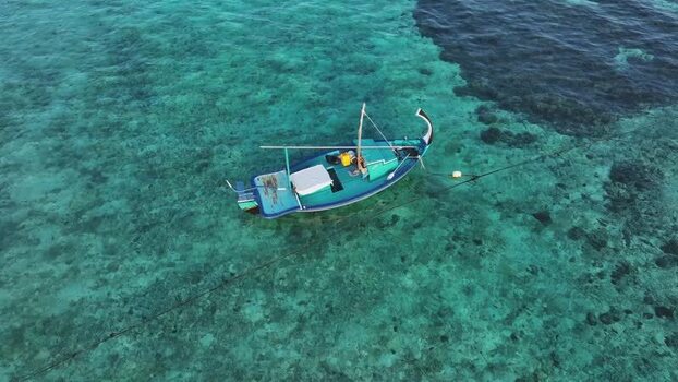 Aerial view of a traditional boat in turquoise water Maldives. Aerial view of a traditional boat in turquoise water Maldives.