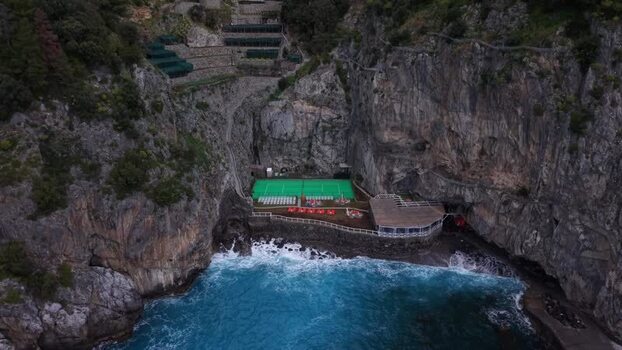 Aerial view of tennis court near cliffs Italy.