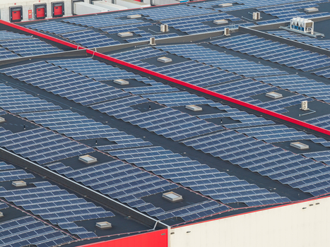 Aerial view of a large industrial building rooftop covered with extensive solar panel arrays for renewable energy generation in Genk Flanders Belgium. Aerial view of a large industrial building rooftop covered with extensive solar panel arrays for renewable energy generation in Genk Flanders Belgium.