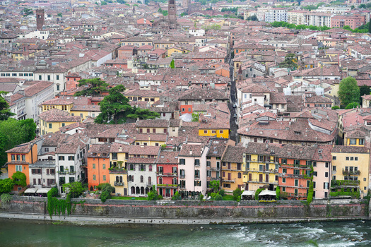 Aerial view of historic colorful buildings along the Adige river with terracotta rooftops and narrow streets in Verona Veneto Italy.
