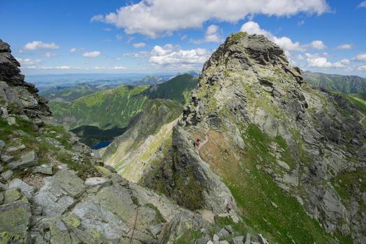 View of Tri kopy in Western Tatras with hikers on a rocky mountain ridge under a blue sky with clouds Ziar Zilina Region Slovakia. View of Tri kopy in Western Tatras with hikers on a rocky mountain ridge under a blue sky with clouds Ziar Zilina Region Slovakia.