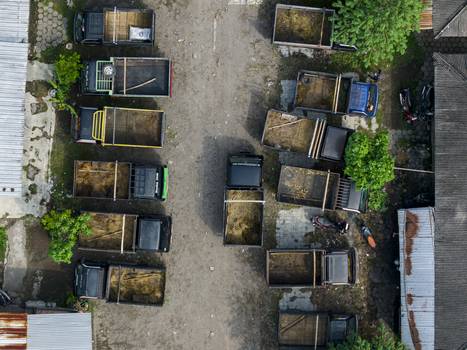 Aerial view of Animal Market Prambanan with several pickup trucks parked on a dirt ground near rooftops and trees Kecamatan Prambanan Jawa Tengah Indonesia. Aerial view of Animal Market Prambanan with several pickup trucks parked on a dirt ground near rooftops and trees Kecamatan Prambanan Jawa Tengah Indonesia.