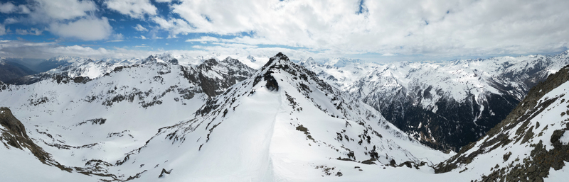 Aerial view of snow capped mountains reach for a sky brushed with clouds a stark contrast of white and grey Arpy Valle d Aosta Italy. Aerial view of snow capped mountains reach for a sky brushed with clouds a stark contrast of white and grey Arpy Valle d Aosta Italy.