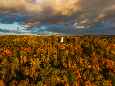 Aerial view of the Three Crosses monument amidst a sea of autumn foliage painted with the warm hues of sunset beneath a brooding sky Vilnius Lithuania. Aerial view of the Three Crosses monument amidst a sea of autumn foliage painted with the warm hues of sunset beneath a brooding sky Vilnius Lithuania.
