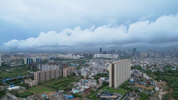 Aerial view of Gurugram skyscrapers and monsoon clouds India.