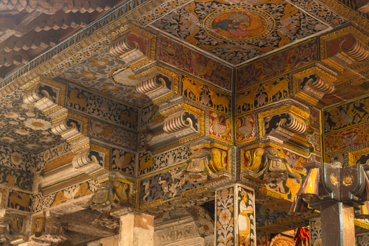 View of the ornate hand painted wooden ceiling and carved pillars featuring traditional Kandyan motifs and animal figures in Kandy Central Province Sri Lanka. View of the ornate hand painted wooden ceiling and carved pillars featuring traditional Kandyan motifs and animal figures in Kandy Central Province Sri Lanka.