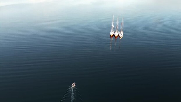 Aerial view of sailboats and a motorboat in Senja Norway. Aerial view of sailboats and a motorboat in Senja Norway.