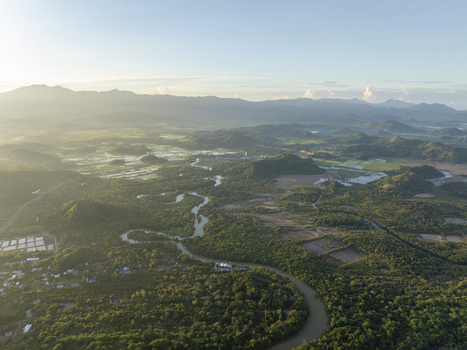 Aerial view of a winding river flowing through lush tropical forests and green hills near Labuan Bajo Komodo East Nusa Tenggara Indonesia. Aerial view of a winding river flowing through lush tropical forests and green hills near Labuan Bajo Komodo East Nusa Tenggara Indonesia.