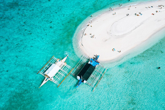 Aerial view of Sumilon Island sandbar with traditional outrigger boats anchored in the turquoise waters of Oslob Cebu Philippines. Aerial view of Sumilon Island sandbar with traditional outrigger boats anchored in the turquoise waters of Oslob Cebu Philippines.