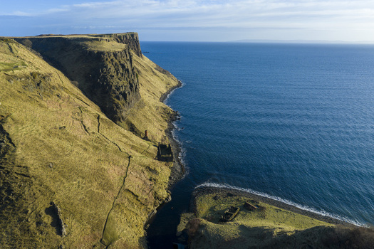 Aerial view of Lealt Falls and the historic diatomite factory ruins on the rugged coastline of Isle of Skye Scotland United Kingdom. Aerial view of Lealt Falls and the historic diatomite factory ruins on the rugged coastline of Isle of Skye Scotland United Kingdom.