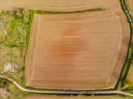 Aerial view of the ploughed agricultural field at Castlefields with visible tractor tracks and surrounding hedgerows in Stafford England United Kingdom. Aerial view of the ploughed agricultural field at Castlefields with visible tractor tracks and surrounding hedgerows in Stafford England United Kingdom.