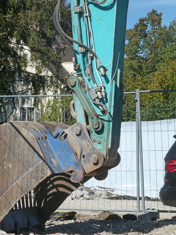 View of a heavy excavator bucket and hydraulic arm at a demolition and road construction site in Garching Bavaria Germany. View of a heavy excavator bucket and hydraulic arm at a demolition and road construction site in Garching Bavaria Germany.